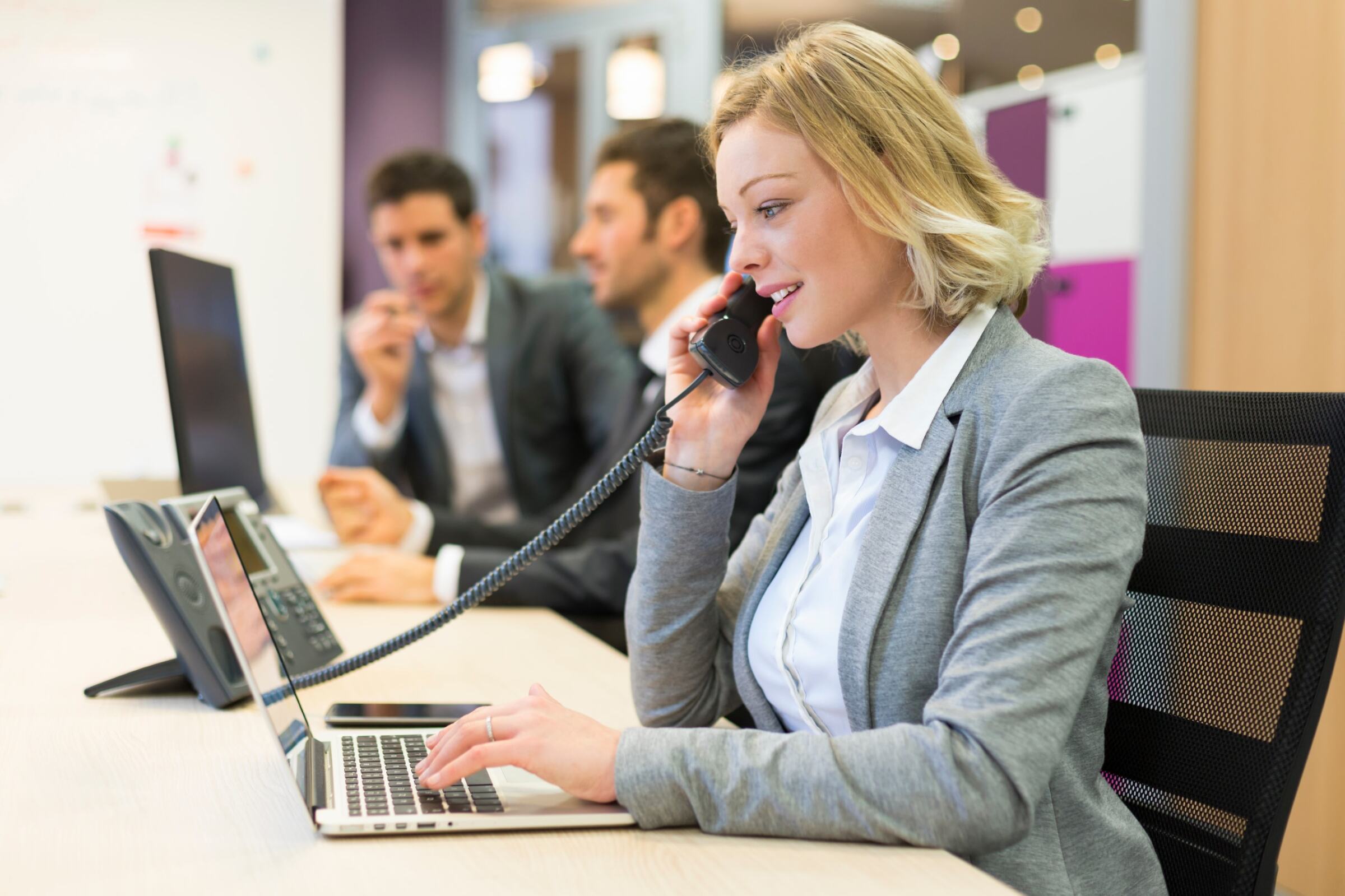 Businesswoman talking on phone in a financial services firm with phone and internet service provided by Kinetic Business