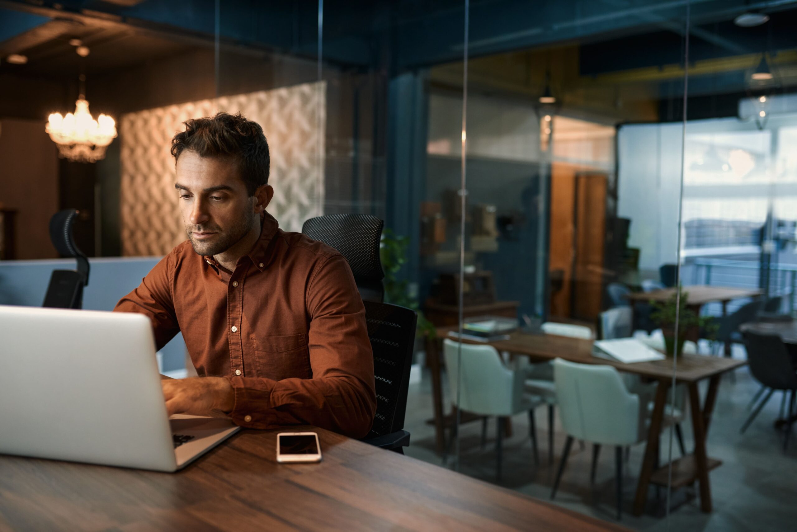 Casual businessman working on his laptop after hours in an office powered by Kinetic Business fiber internet service