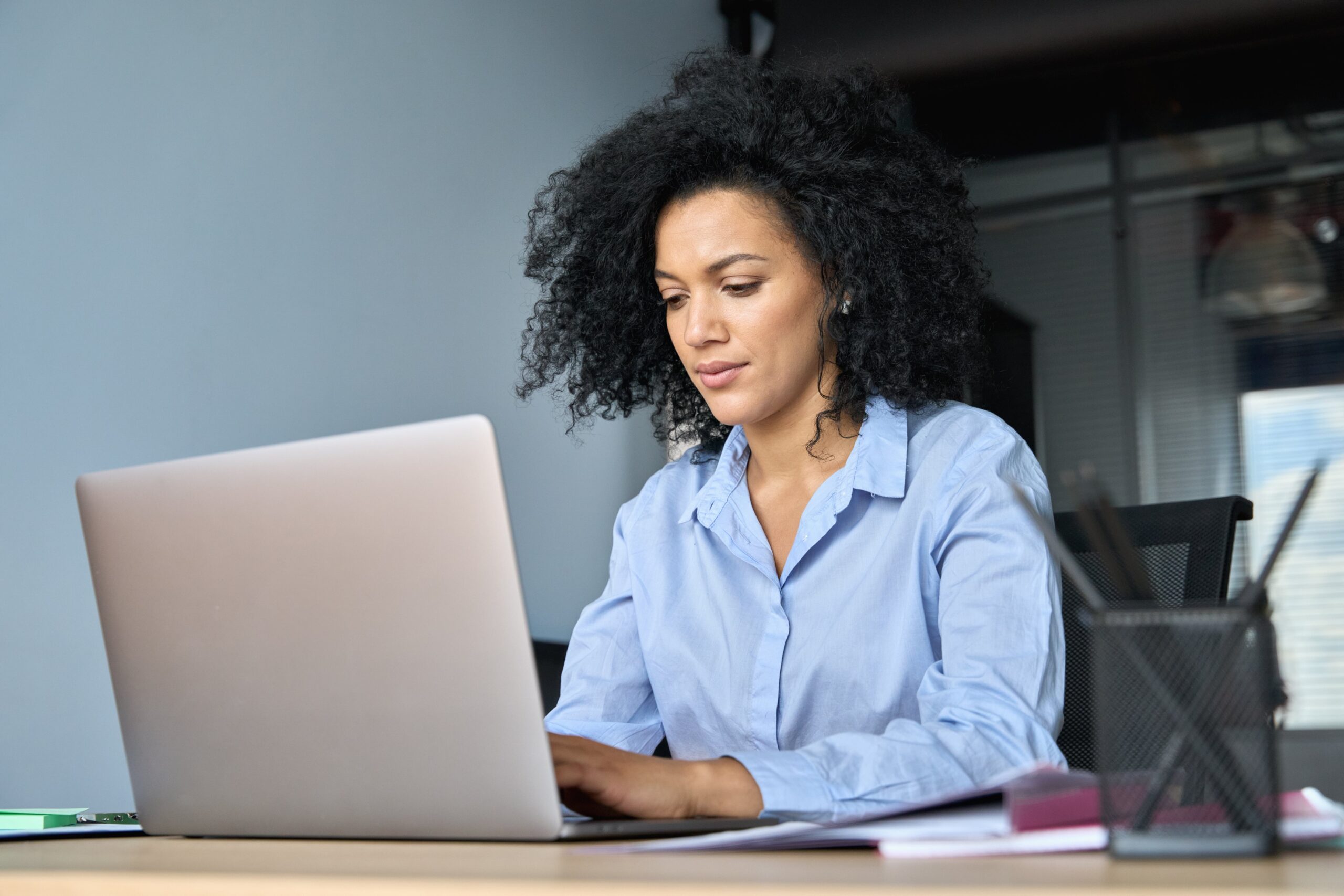 Lawyer sitting at desk typing on her laptop in office connected to the internet by high speed Kinetic Business fiber internet