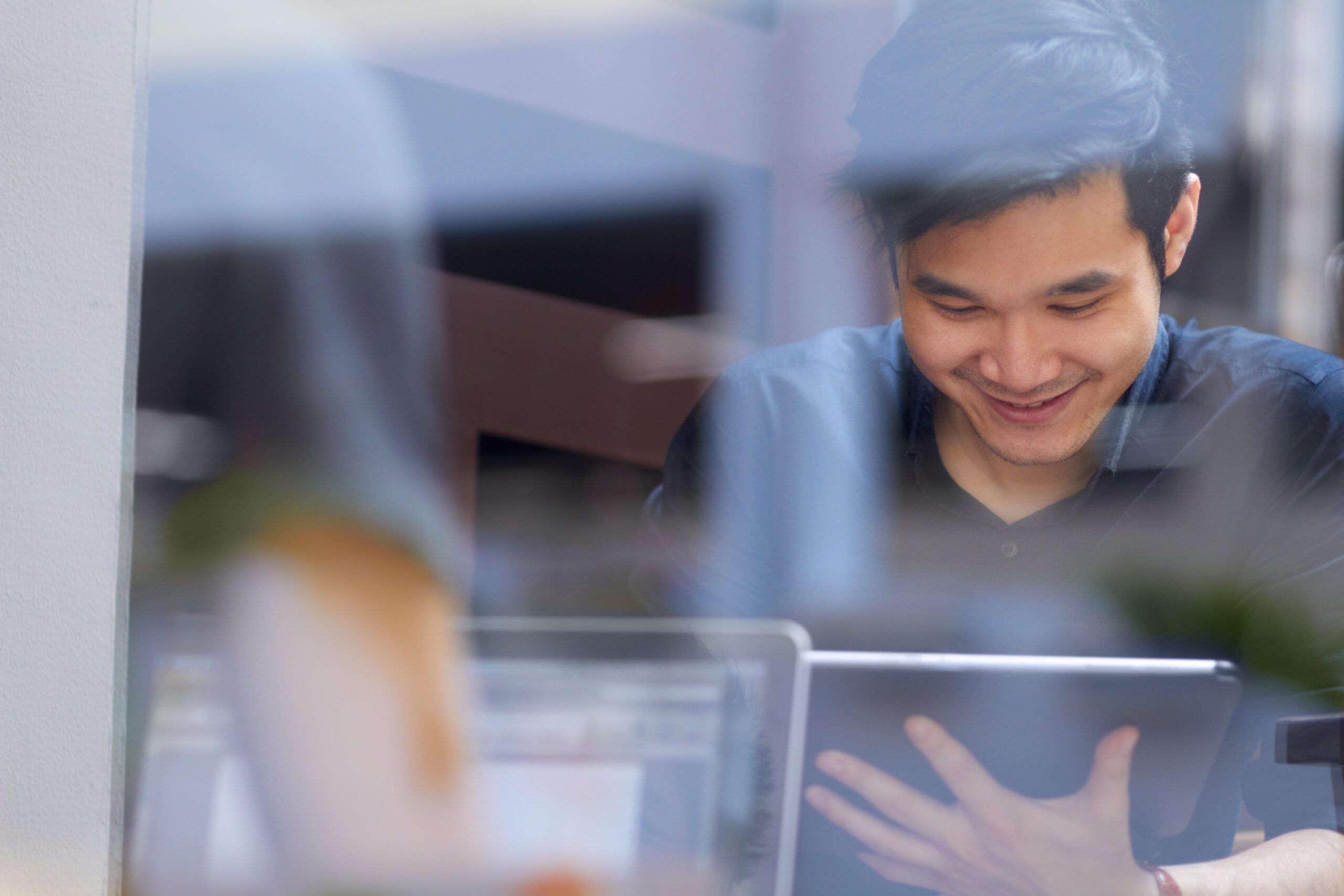 Smiling customer uses his digital tablet inside an internet cafe powered by Kinetic Business high speed internet service