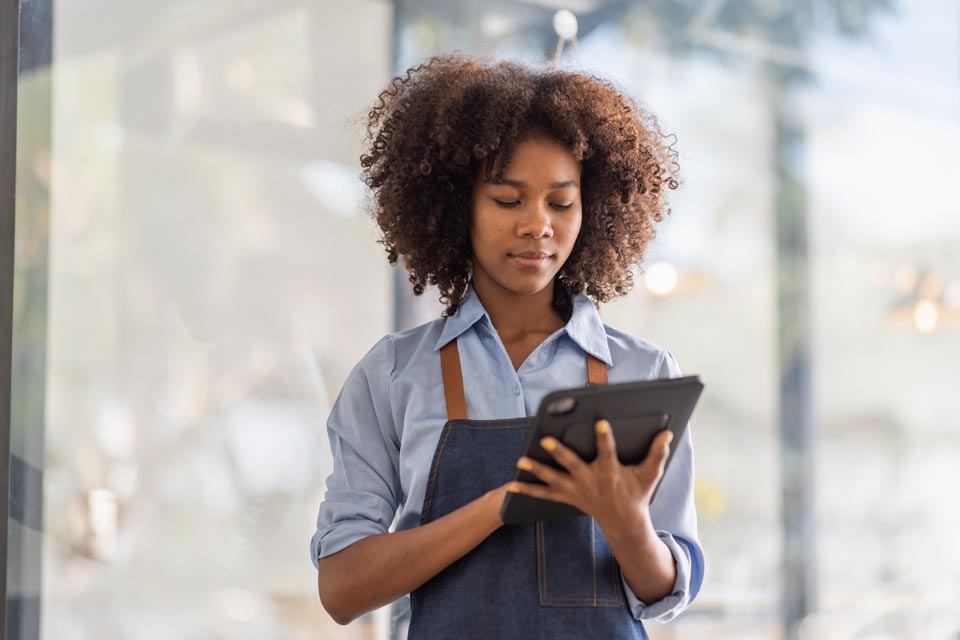 Small business owner works on her tablet connected to the internet on WIFI powered by service from Kinetic Business