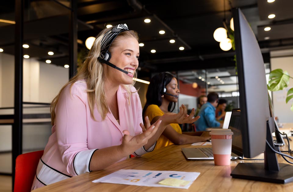 Smiling call customer service rep with headset helps a customer using phone and internet bundled by Kinetic Business