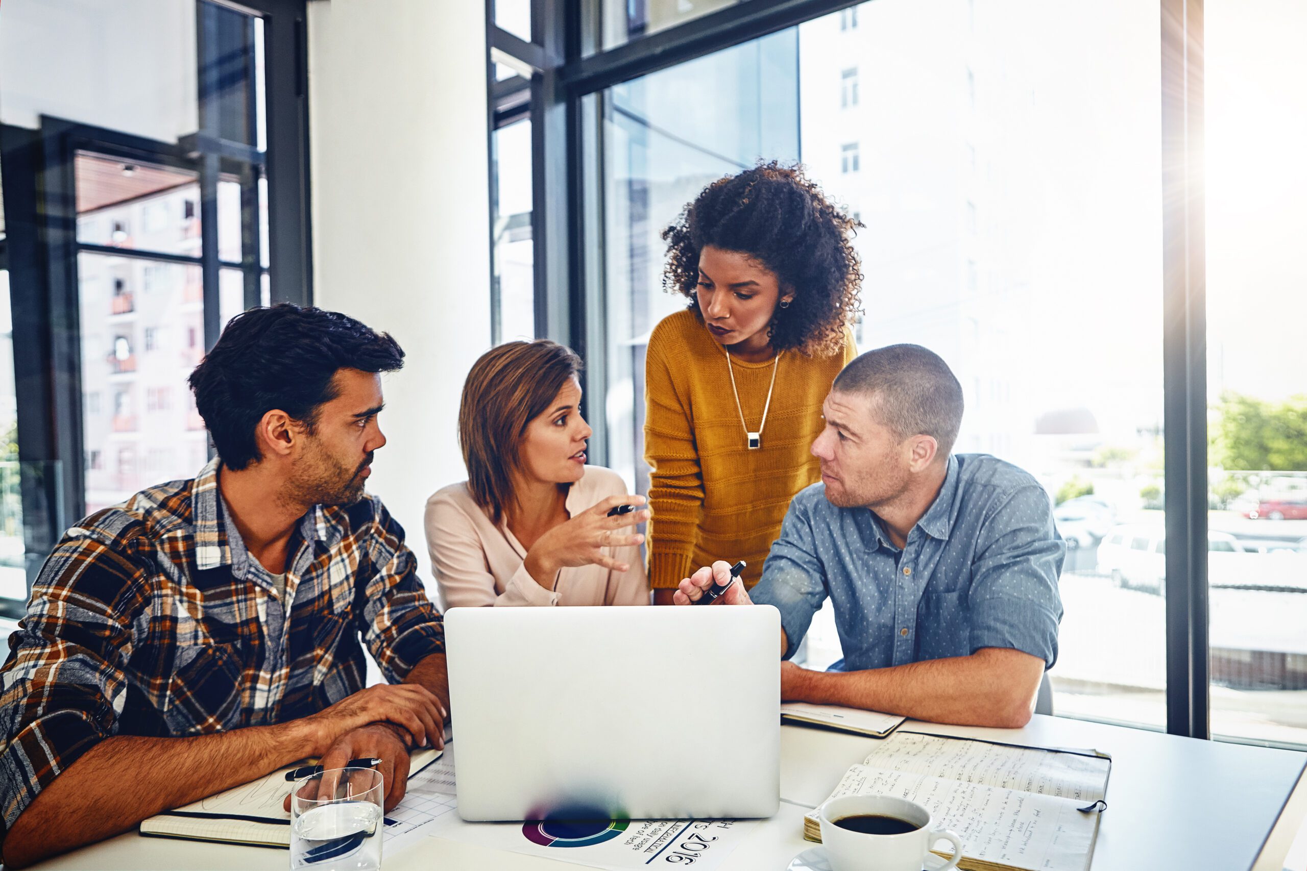 Employees in a creative agency discuss a project viewed on a computer via a Kinetic Business fiber internet connection.