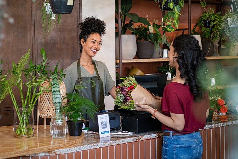 Small business retail cashier assists customer at the register.