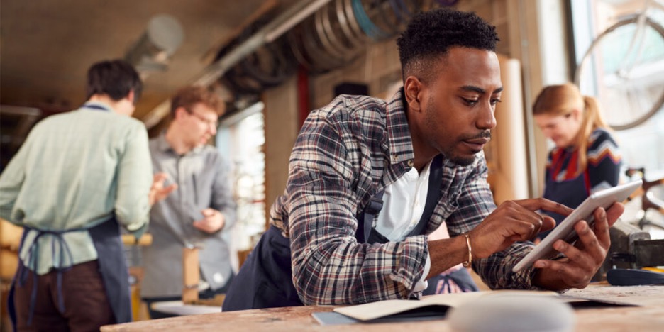 young man using device connecting bike shop with 3 coworkers